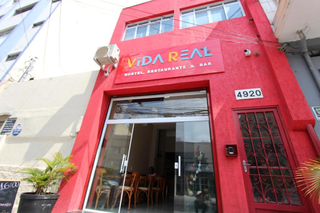 圣保罗Vida Real Hostel的餐厅红色的外墙,有红色的门
