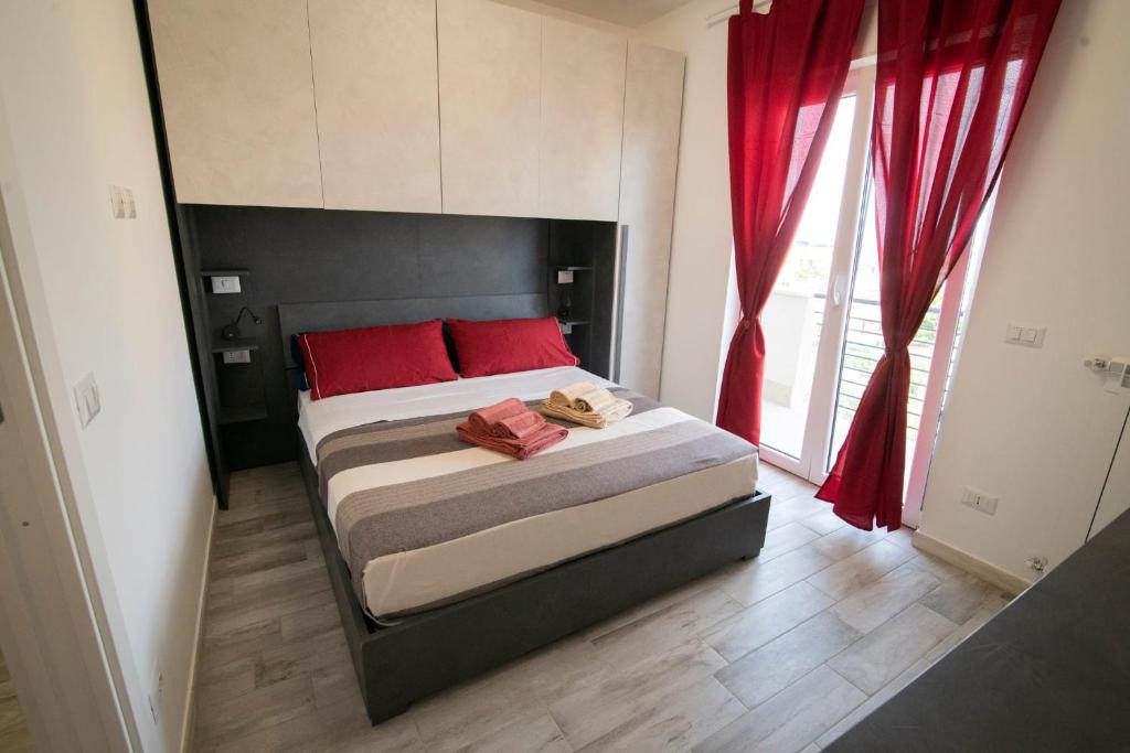马里诺Casa Larry的一间卧室配有一张带红色枕头的大床