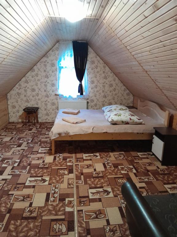 亚布卢尼齐亚Котеджі "У Яни"的一间卧室配有一张床,地板上设有窗户