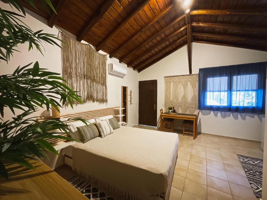梅加利阿莫斯Spitaki Guest House的卧室里有一床,房间里还有植物