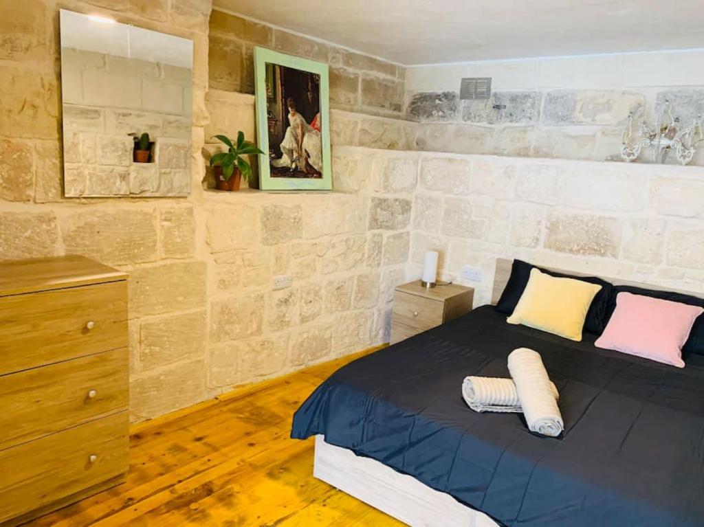QormiSerenity的卧室配有一张石墙内的特大号床