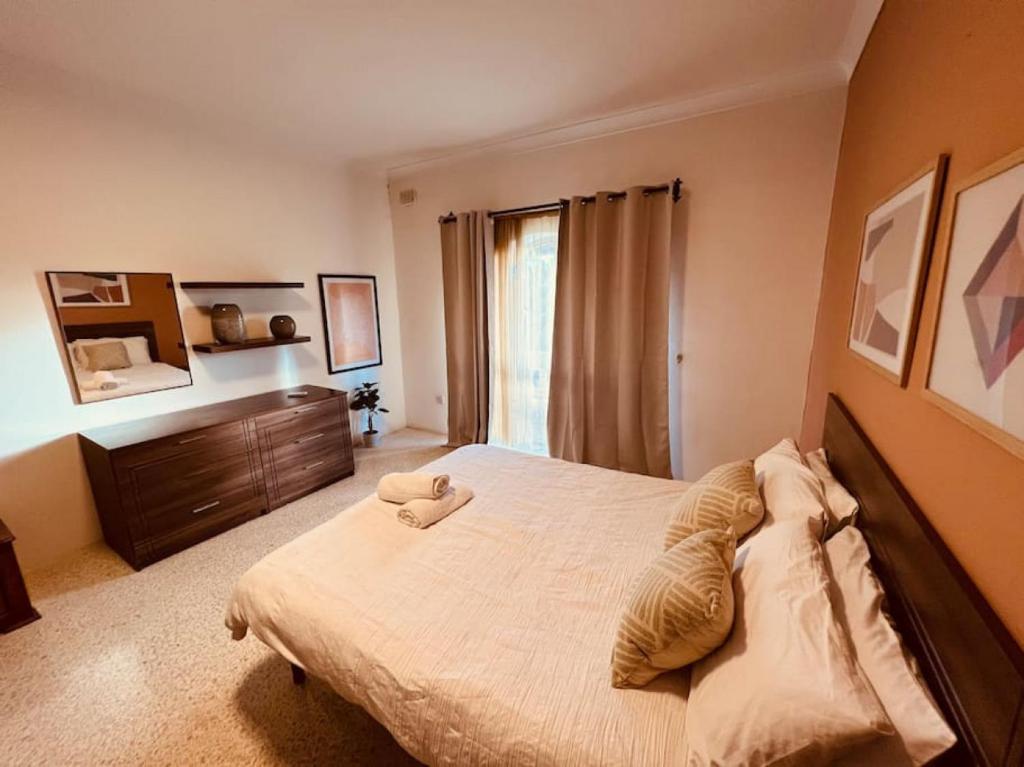 SiġġiewiLovely 3 bedroom in Siggiewi的一间卧室配有一张大床和一个梳妆台