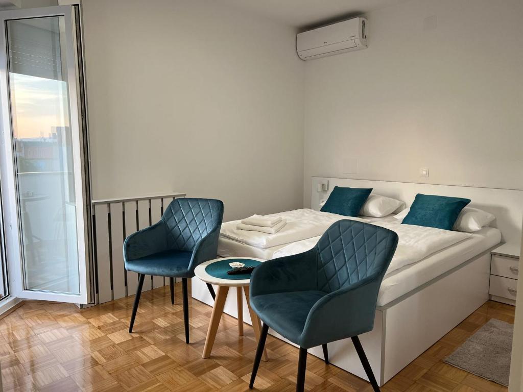 普纳特Villa Rosa Rooms的一间卧室配有一张带两把椅子和一张桌子的床。