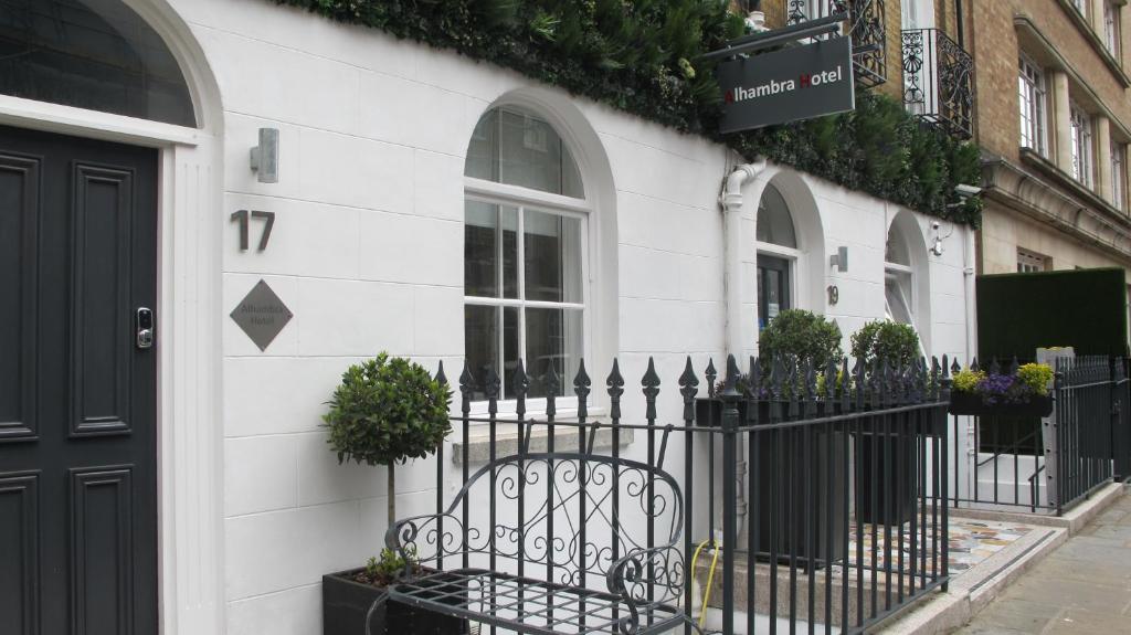伦敦阿尔罕布拉酒店的白色的建筑,有黑色的栅栏和盆栽植物