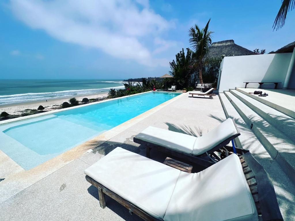 斯基灵角Villa ALDIANA的一个带躺椅的游泳池,毗邻大海