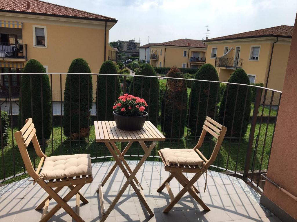 Castiglione OlonaAppartamento BELVEDERE的阳台上摆放着两把椅子和一张桌子,上面放着盆子