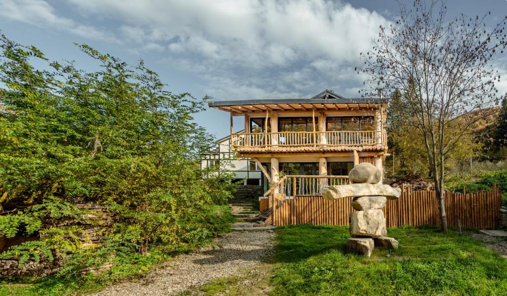 Gura TeghiiOM Resort的带阳台和房屋的木屋