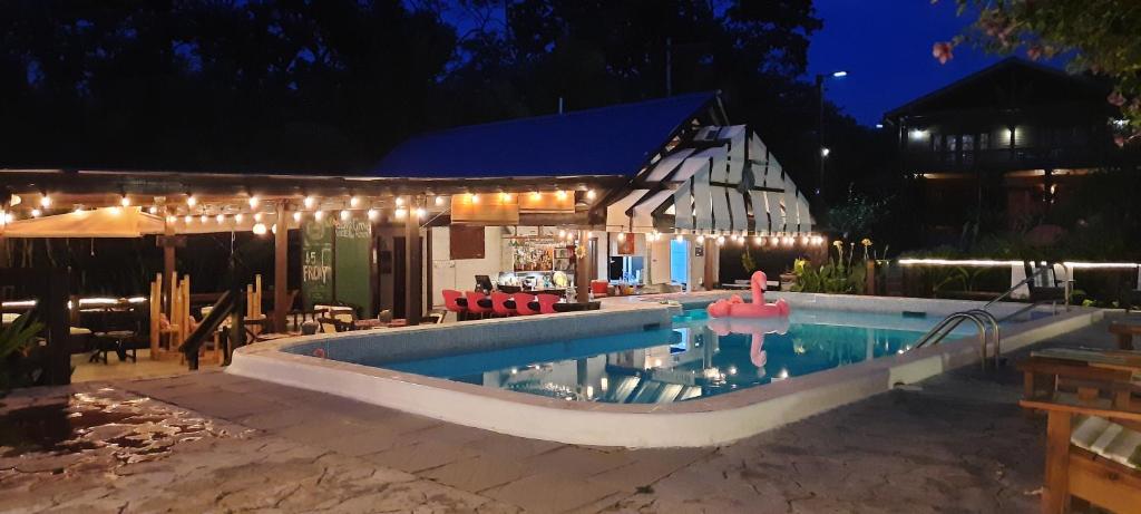 桑迪湾Guava Grove Resort & Villas的夜间在房子前面的游泳池