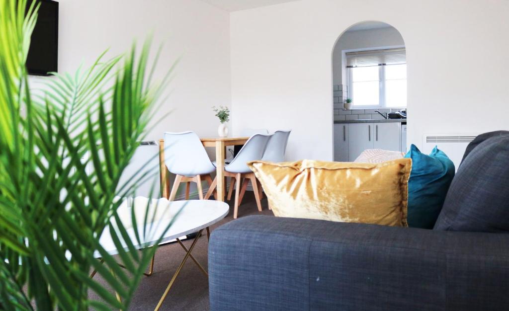 哈罗Flat in London- Modern 2 Bedroom Apartment Harrow near Wembley的客厅配有蓝色的沙发和桌子