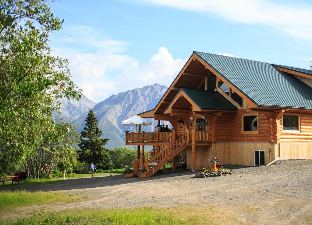 SuttonMajestic Valley Wilderness Lodge的小木屋设有甲板,背景为山脉