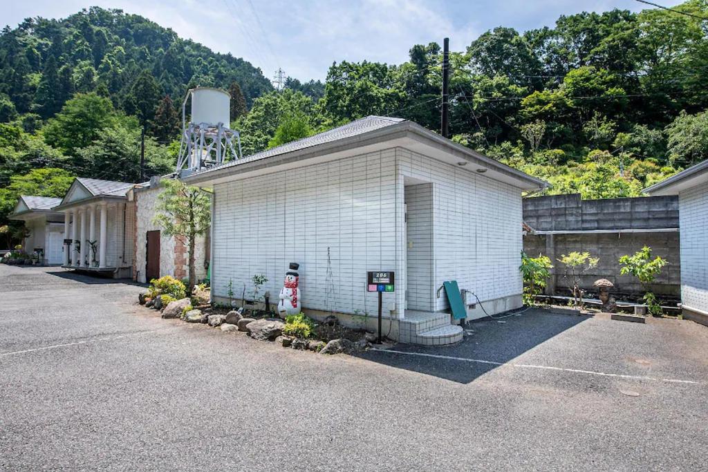 SōgayatoHotel Takao Asiel的一座白色的建筑,上面有水塔