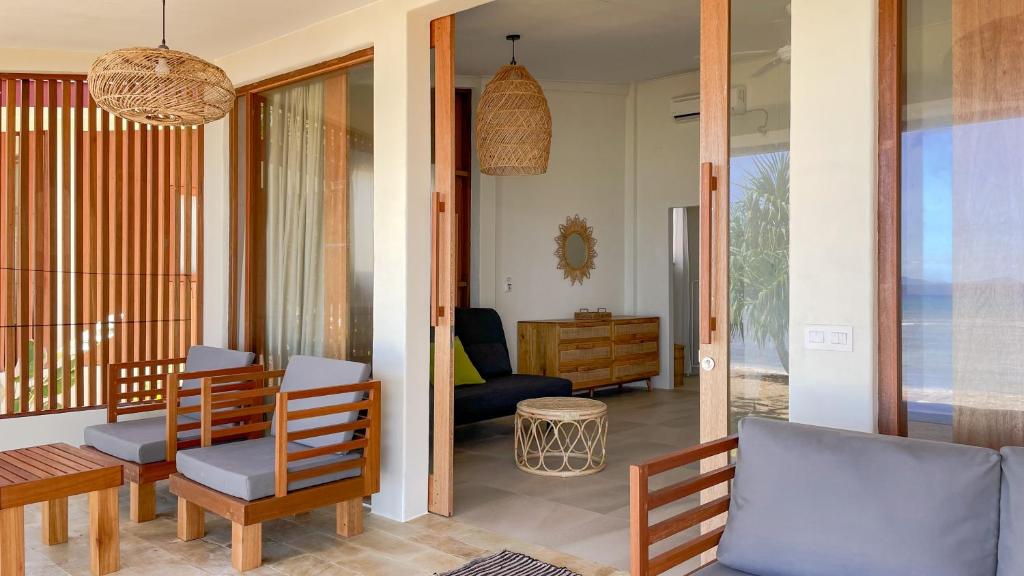 沙璜Sunset Beach Resort Weh的客厅配有木椅和桌子