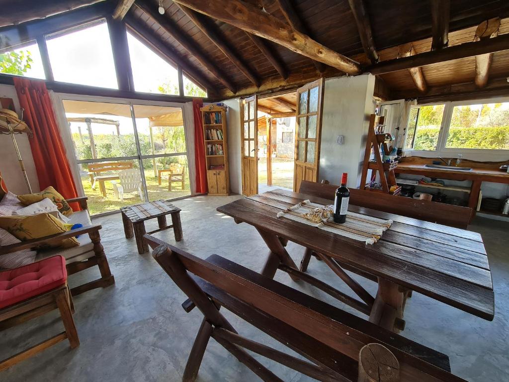 Los ÁrbolesEspacio Nux的客房设有一张带一瓶葡萄酒的木桌。