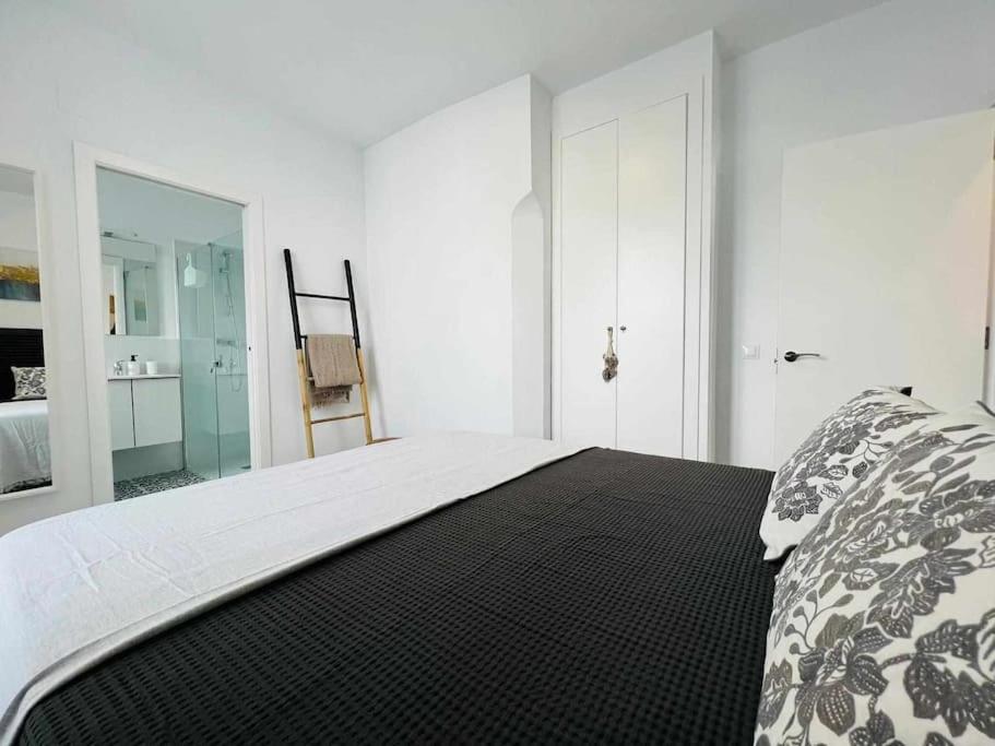 麦地那西多尼亚Casa Las 4 Esquinas by Casas con Encanto的白色卧室配有一张带黑白毯子的床