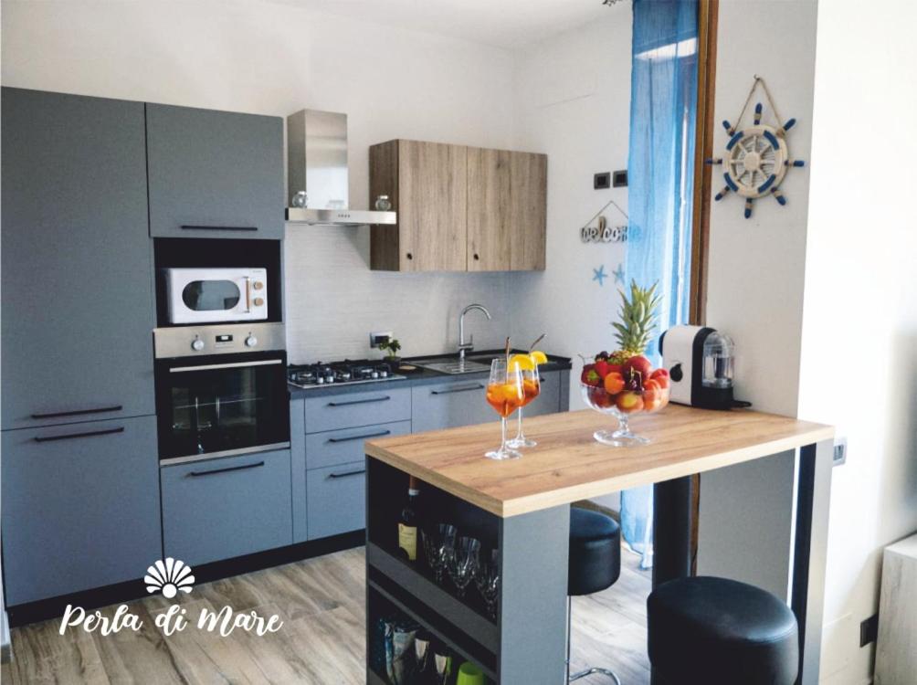 皮昂比诺Appartamento Perla di Mare的厨房配有蓝色橱柜和饮料柜台。