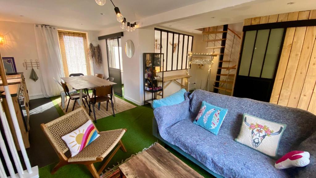 莫雷卢安河La MaisonneTTe d'ElodibiZa !的客厅配有蓝色的沙发和桌子