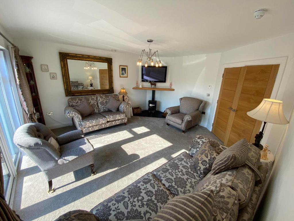 当纳德尔Ardbrin Lodge的客厅配有沙发、椅子和电视