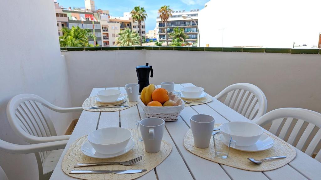 洛斯克里斯蒂亚诺斯La Palmera - Apartamento a 600mt de la playa - Los Cristianos的阳台上的白色桌子和一碗水果
