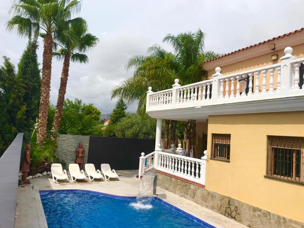 卡斯特利翁-德拉普拉纳Villa Holiday的房屋前有游泳池的房子