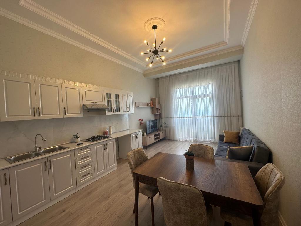 苏姆盖特Caspian Pearl Residence的一间带桌子的客厅和一间厨房