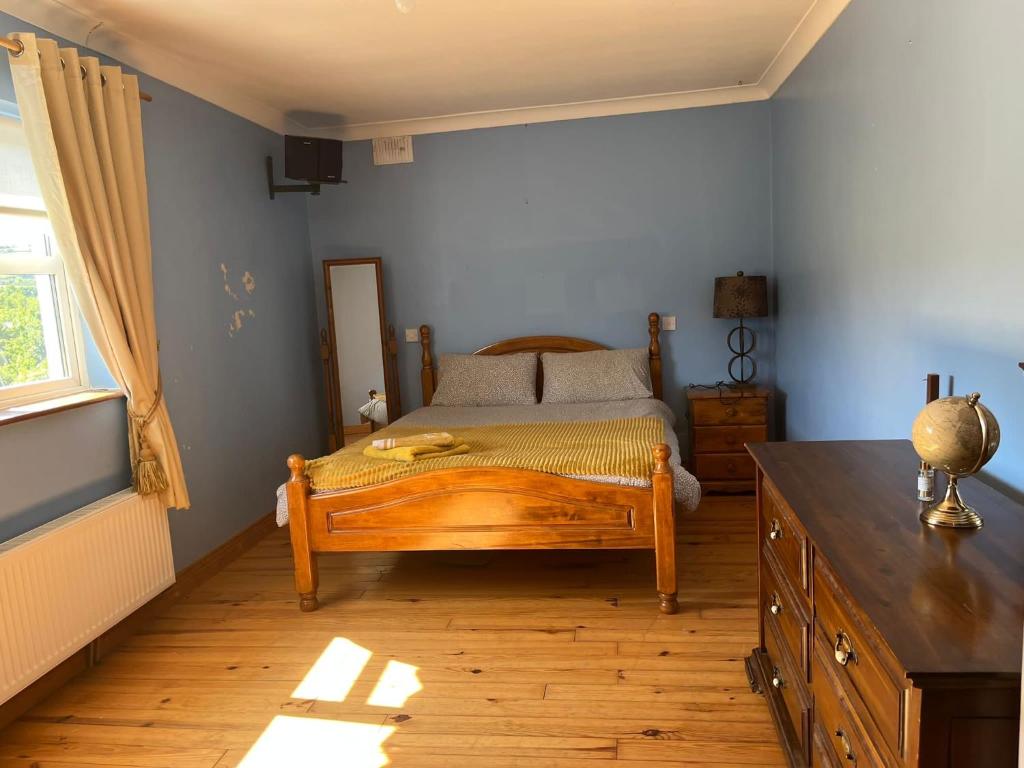 Graiguenamanaghgraiguenamanagh Homestay的一间卧室配有一张木床和木制梳妆台