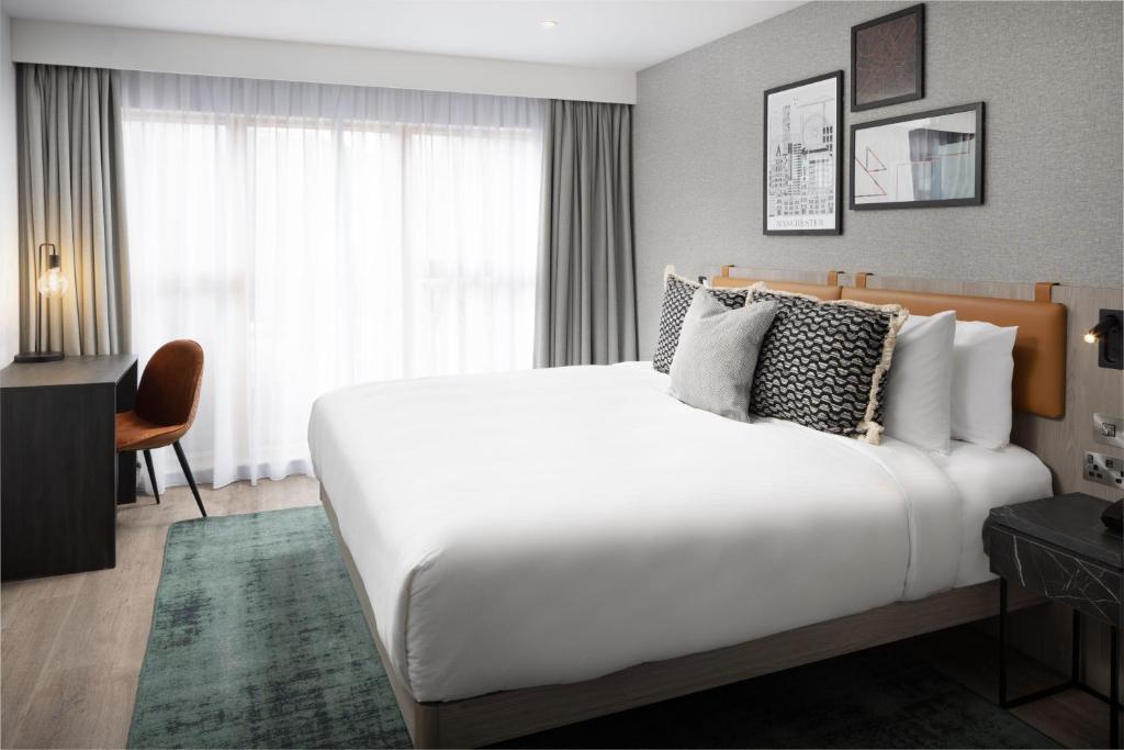 曼彻斯特Residence Inn by Marriott Manchester Piccadilly的卧室设有一张白色大床和一扇窗户。