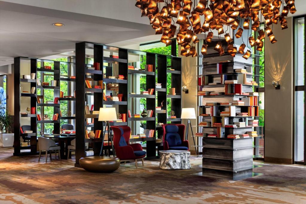 西雅图西雅图万丽酒店的图书馆配有书架、椅子和吊灯