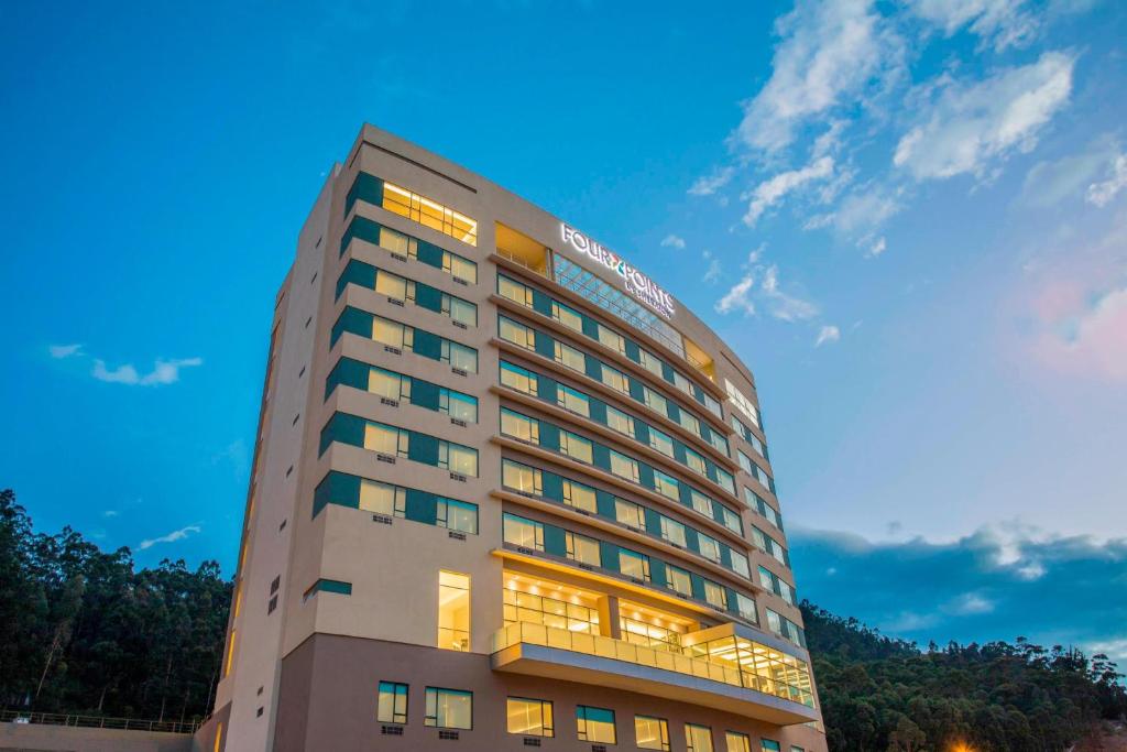 昆卡昆卡福朋喜来登酒店的一座高大的酒店建筑,背景是天空