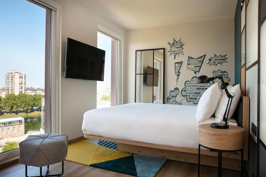 斯特拉斯堡Aloft Strasbourg Etoile的卧室设有一张白色大床和一扇窗户。