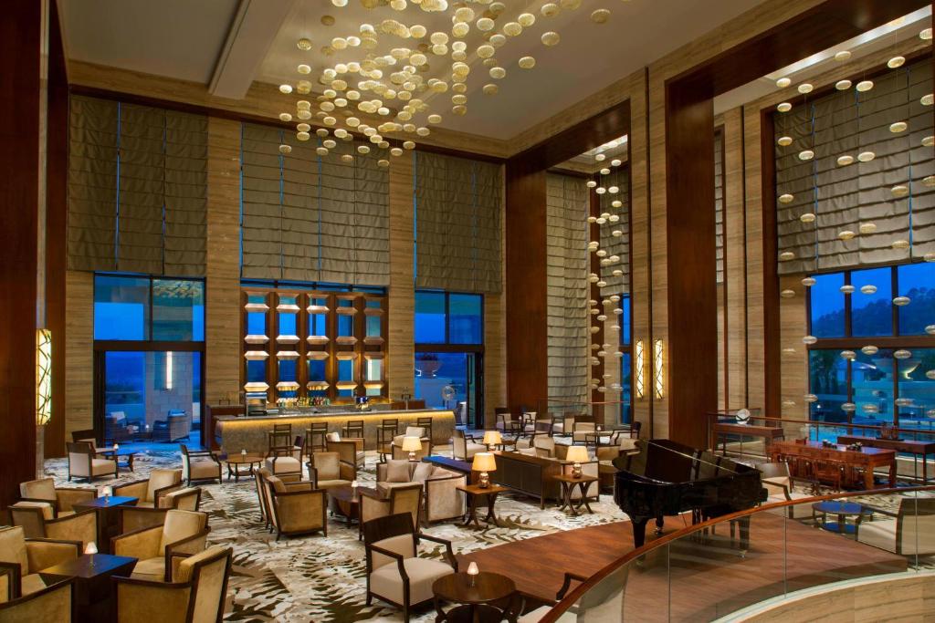惠州惠州白鹭湖雅居乐喜来登度假酒店的大楼内带桌椅的餐厅
