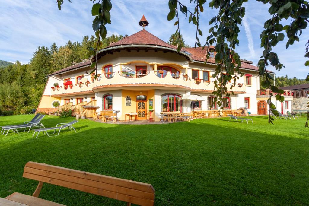 Eberstein凯旋门生态乡村酒店的一座带绿地庭院的大房子,长凳