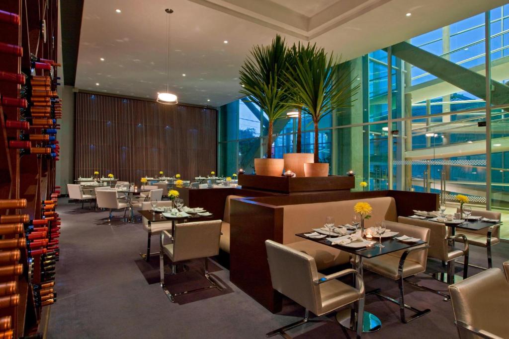 洛斯安赫莱斯Four Points By Sheraton Los Angeles的餐厅设有桌椅和窗户。