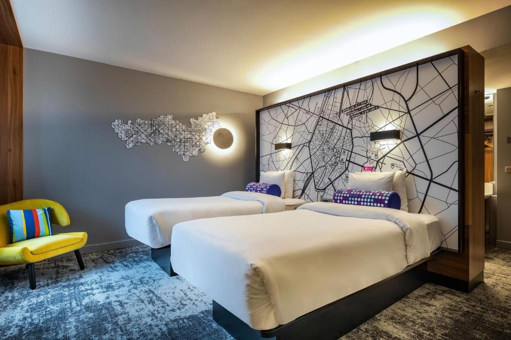 布鲁塞尔布鲁塞尔舒曼雅乐轩酒店的带两张床和黄色椅子的房间