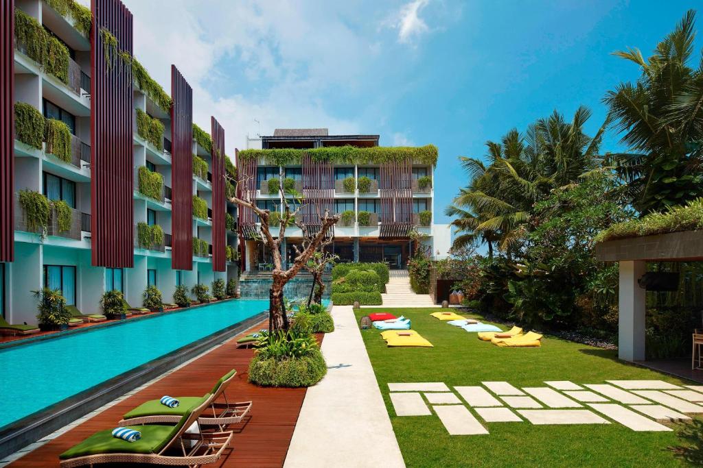 塞米亚克巴厘岛塞米亚克福朋喜来登酒店的一个带游泳池和躺椅的度假胜地和一个度假胜地