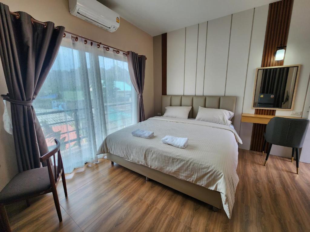 Ban Huai KrathaekLeMae Residence เลอเม เรสซิเดนซ์ อำเภอเขาย้อย เพชรบุรี的一间卧室设有一张床和一个大窗户