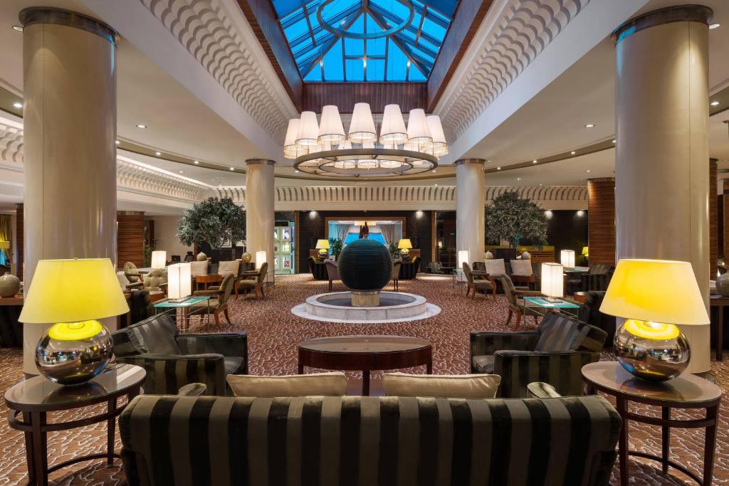 达曼达曼喜来登会议中心酒店的酒店大堂设有桌椅和吊灯。