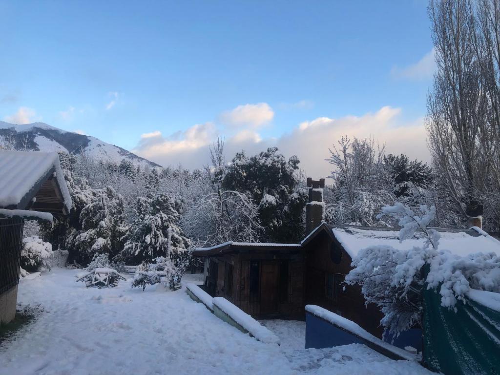 圣卡洛斯-德巴里洛切Cuatro Cerros Hostel的一座带烟 ⁇ 的房子的雪覆盖的院子