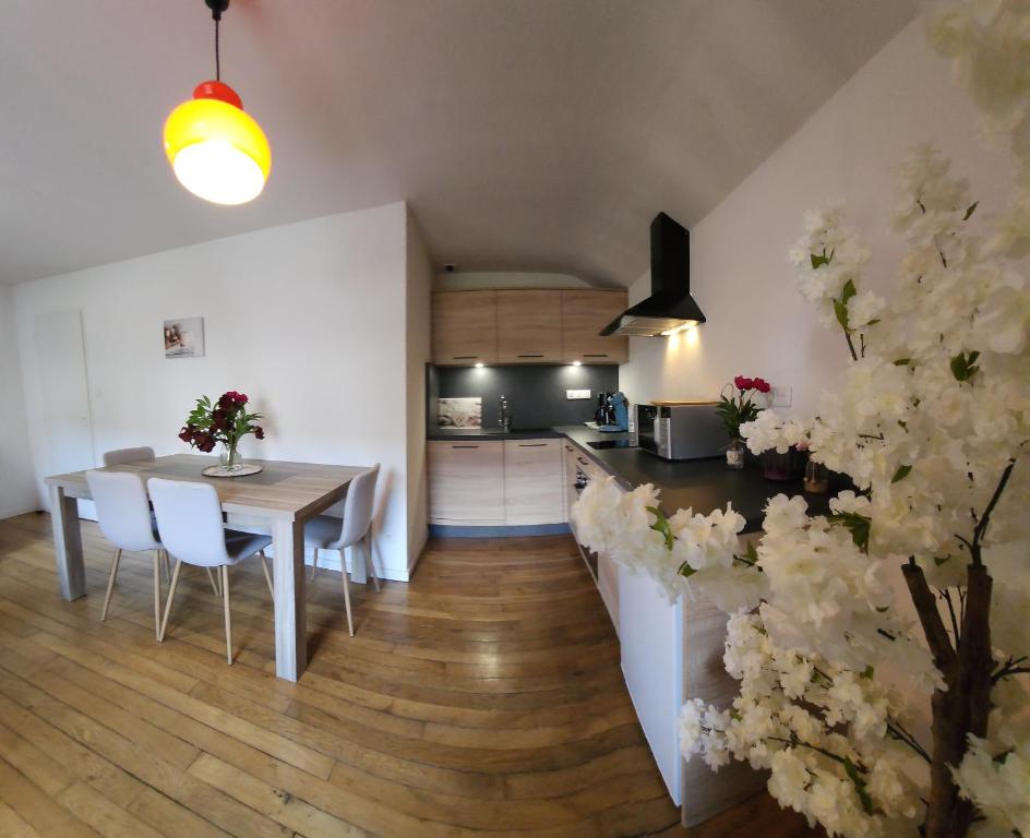 旺特龙Gite Myrtille 2 à 6 personnes dans Residence des Buis avec Spa的厨房以及带桌椅的用餐室。