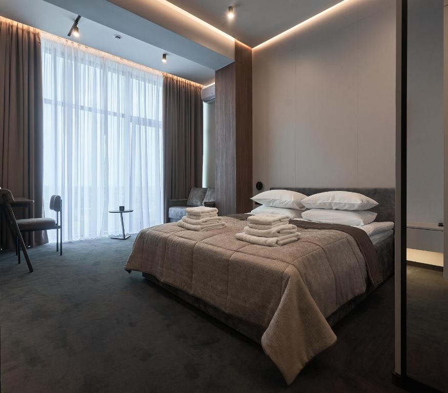 乌日霍罗德WHITE HILLS HOTEL spa&sport的一间卧室配有一张大床和毛巾