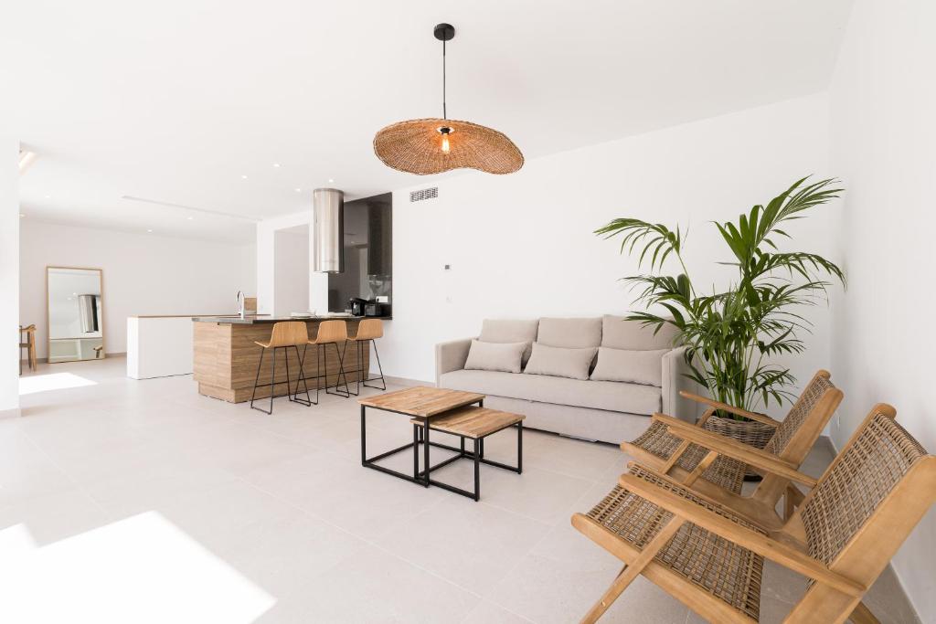 伊维萨镇Bossa Bay Suites with Private Pool - MC Apartments Ibiza的客厅配有沙发和桌子