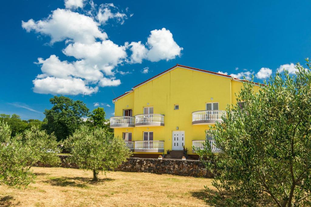 马林斯卡Vila Panorama的黄色的房子,设有白色的阳台和树木