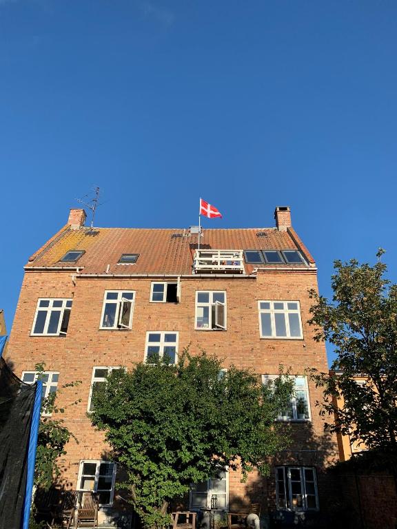伦讷Udsigt Østersøen的一座高大的砖砌建筑,上面有旗帜