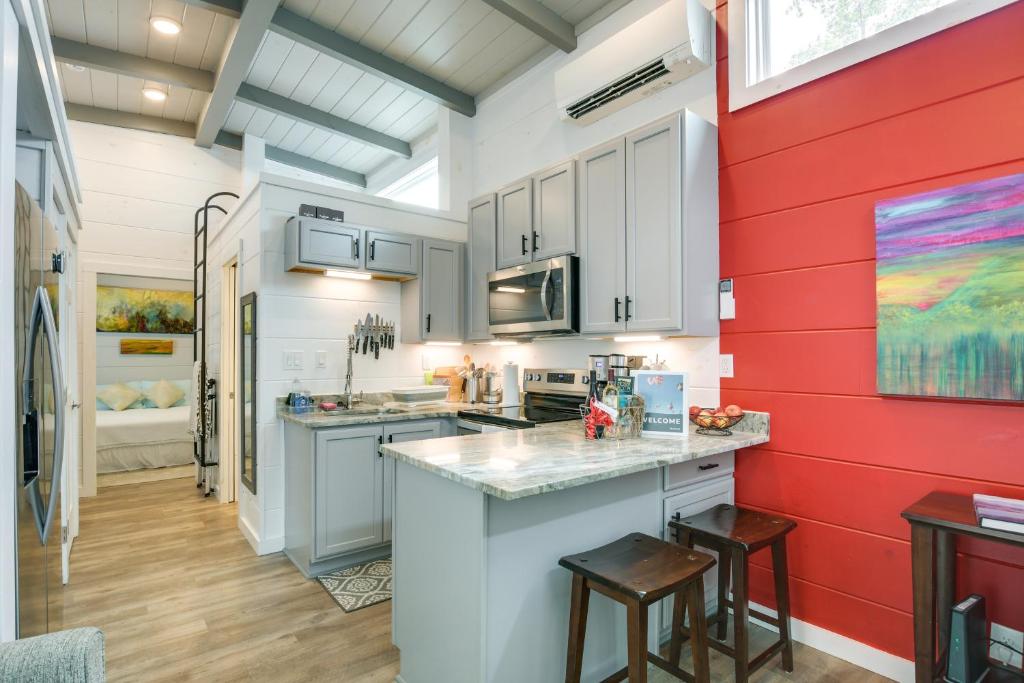 弗拉特罗克Chic Flat Rock Tiny Home with Community Pool Access!的厨房配有白色橱柜和红色墙壁