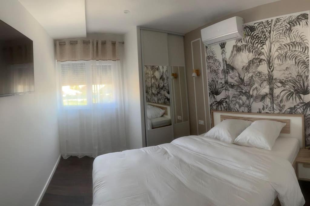 coutancesVilla Jacqueline的卧室配有白色的床和花卉壁纸