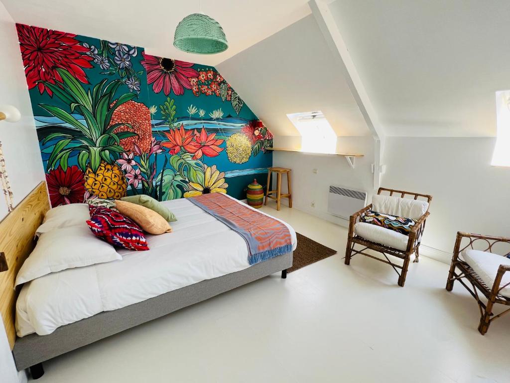 圣伯努瓦德斯昂德Coco bay的一间卧室设有一张带花卉墙壁的大床
