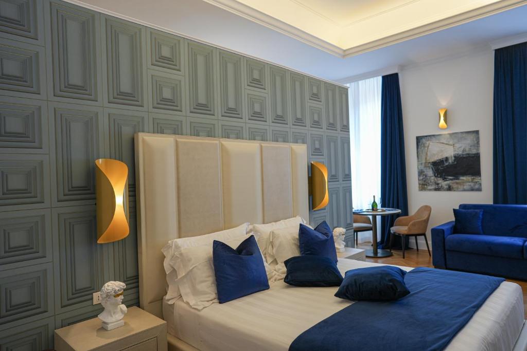 罗马Màs Boutique Hotel Rome的一间卧室配有一张带蓝色枕头的床和一张蓝色沙发。