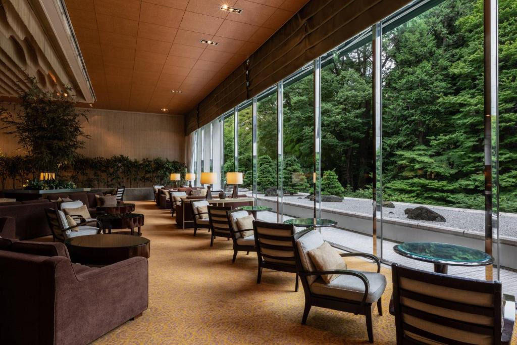 东京东京喜来登米亚科酒店的餐厅设有桌椅和大窗户