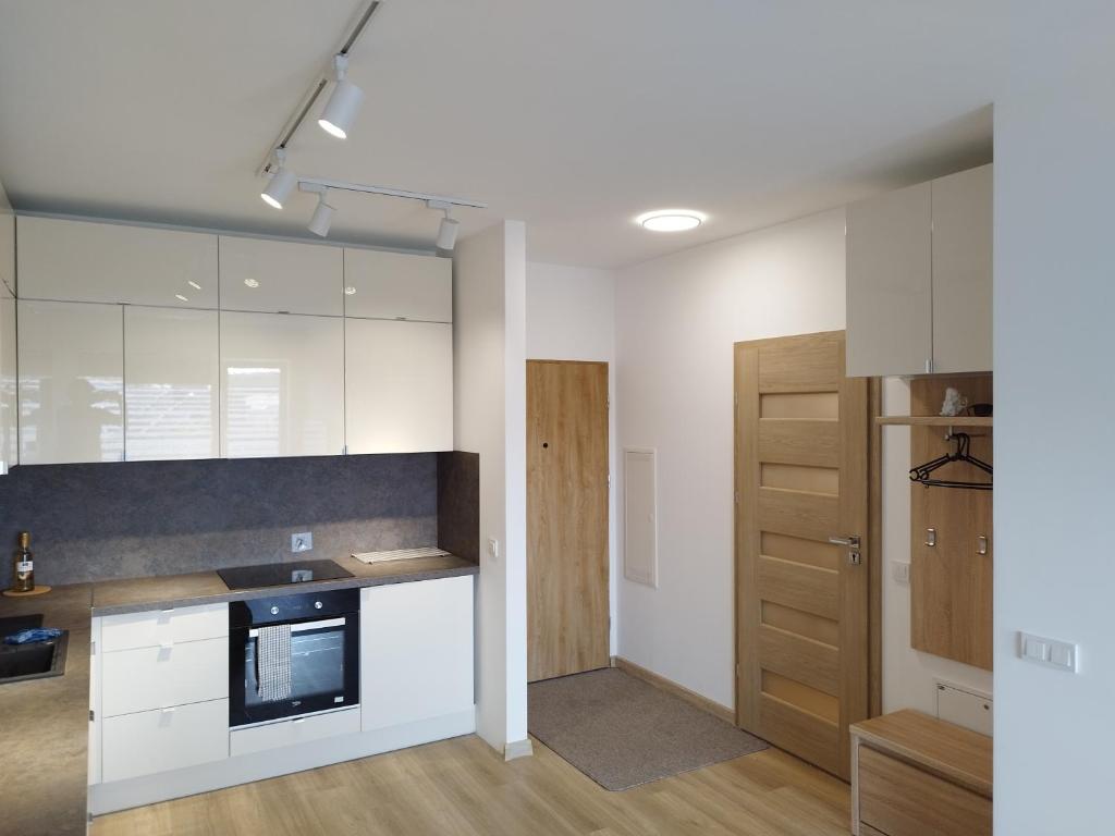 切霍齐内克nowy apartament的厨房配有白色橱柜和台面