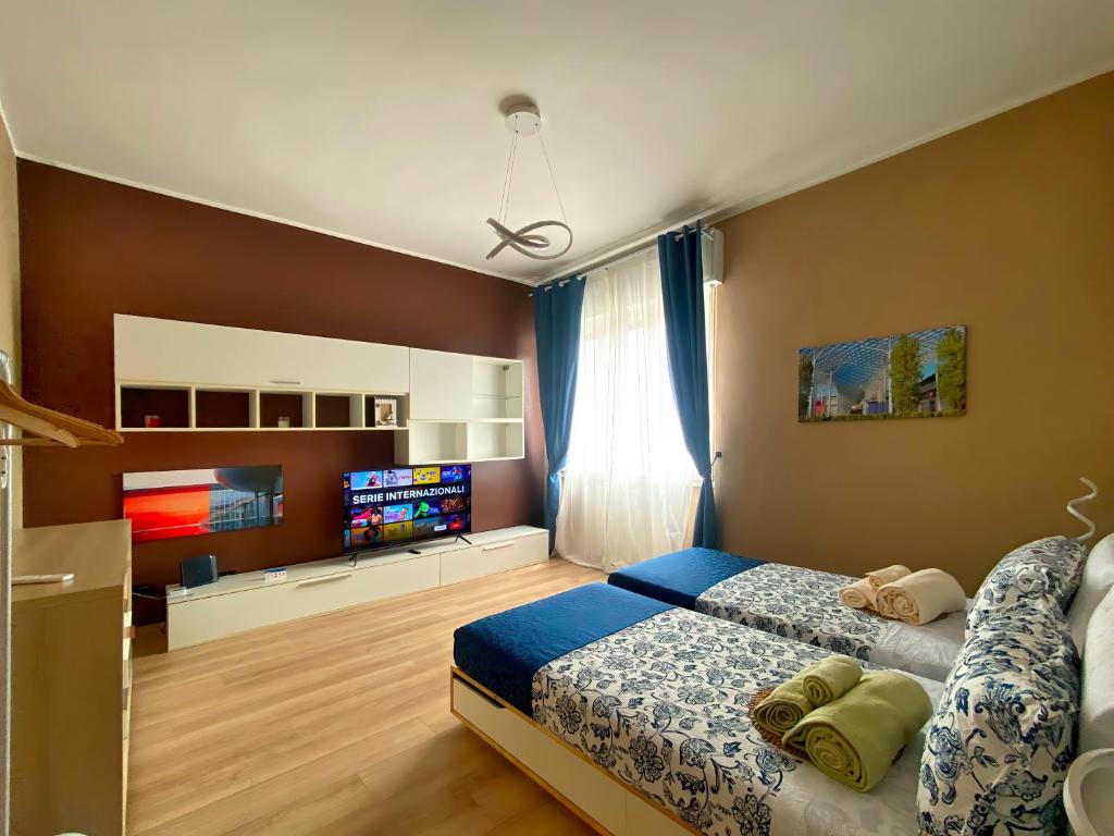 佩罗Rho Fiera Milano Apartment的一间卧室配有一张床和一台平面电视