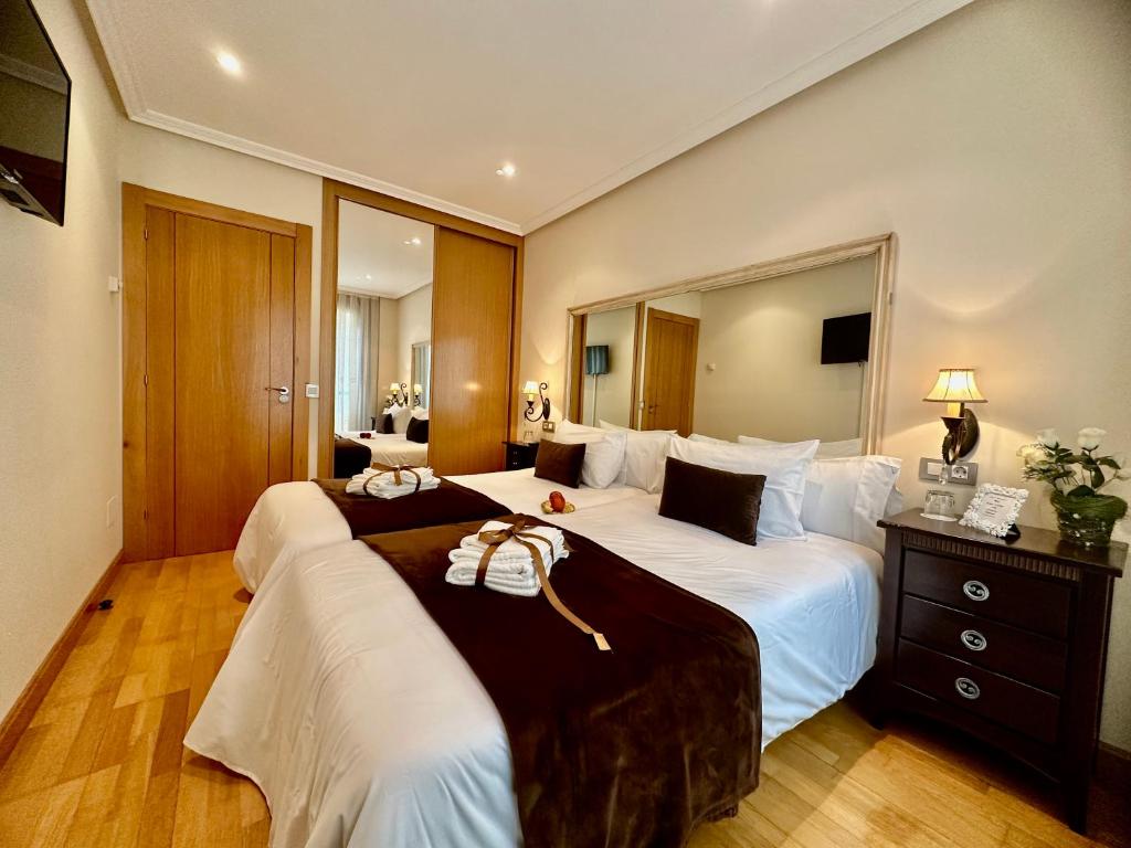 坎加斯德尔纳尔塞亚CLAREN'S GUESTHOUSE的酒店客房,设有两张床和镜子